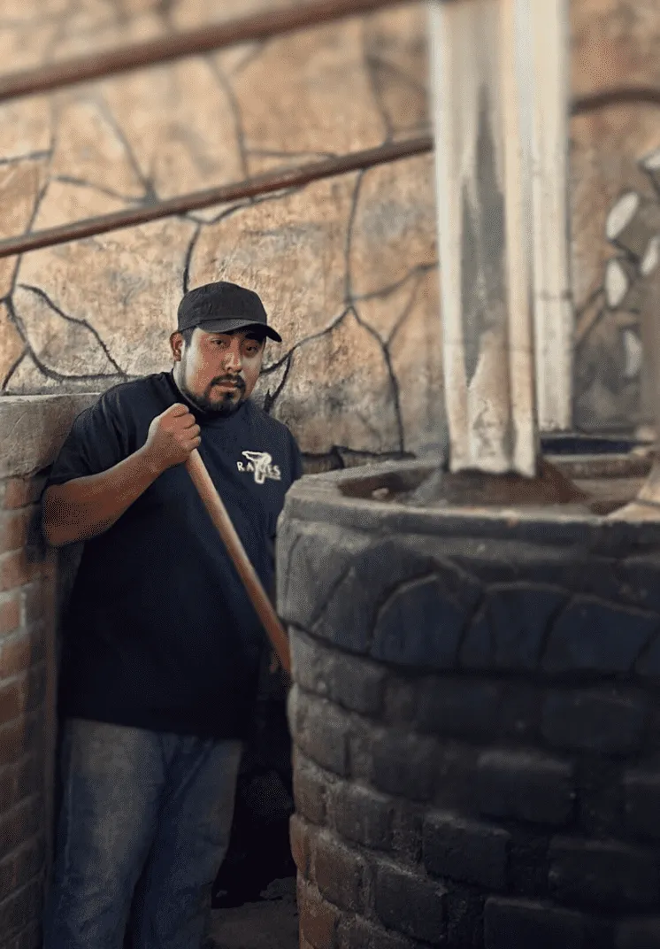 Maestro mezcalero Ambrosio elaborando mezcal artesanal