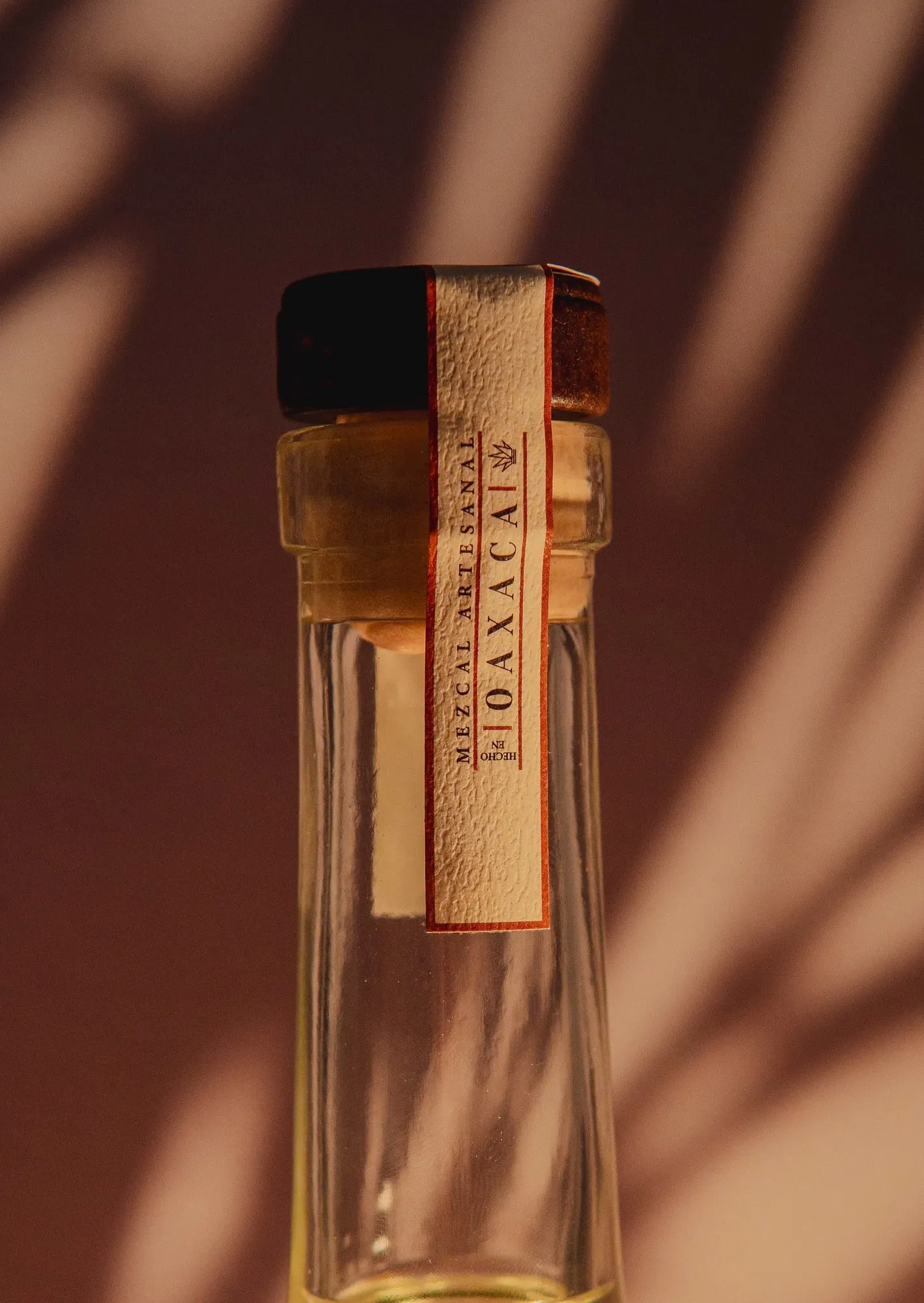 Cuello de una botella de mezcal 7 Raíces con su etiqueta de Oaxaca